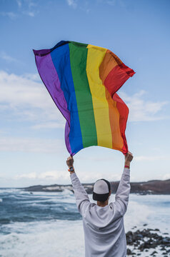 Male tourist holding LGBTQI Flag at El golfo during vacations, Lanzarote, Spain