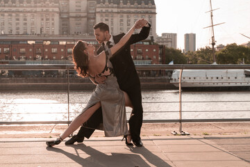 Male and female Tango dancers practicing on pier during summer
