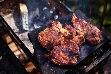 Raw beef burger steak on grill. Cutlet meat placed on grill stone with fire.