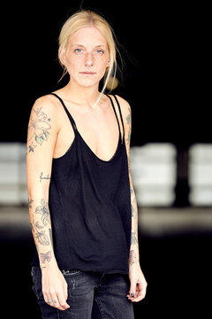 Young woman with tattoo standing at parking garage