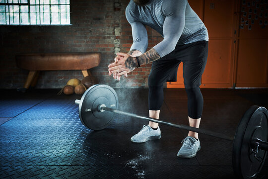Male athlete dusting powder before exercising at gym