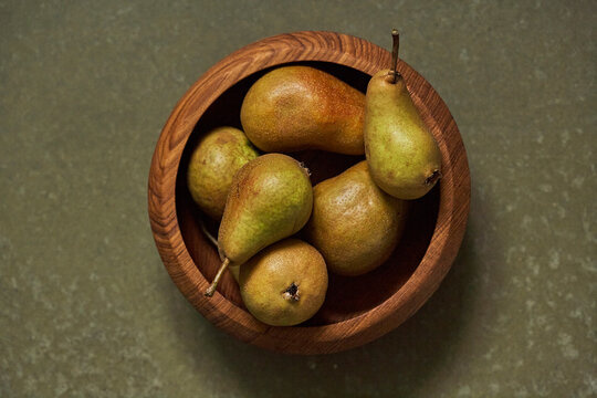 Ripe pears in wooden bowl