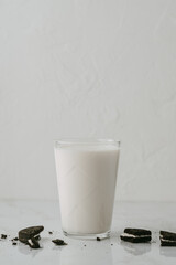 Glass of milk with broken chocolate cookies on the surface. Photo with copy space