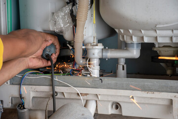 The technician is repairing the washing machine