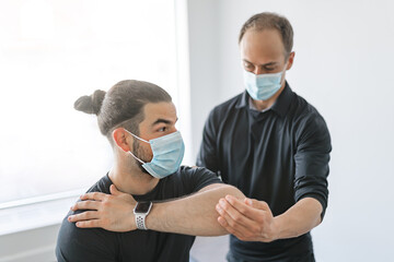 physiotherapist doing therapeutic exercises for patient at the clinic.