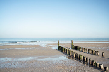 Wood post on beach against clear sky