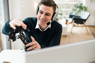 Male professional explaining robotic arm during video conference