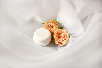 face or hand cream jar on white textile background. concept of natural skin care cosmetics