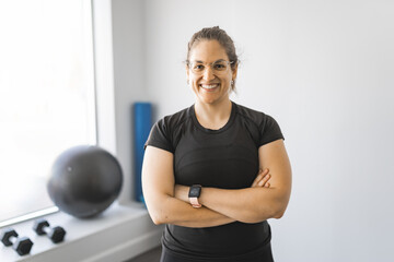 female trainer standing with a smile in the training gym