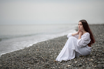 Fototapeta na wymiar Art photo of a girl in a white shirt on the Black Sea coast