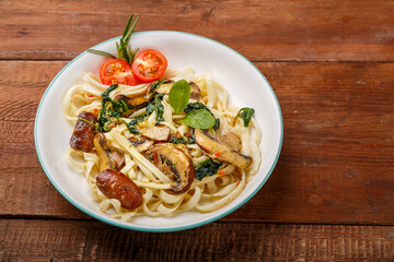 Udon with mushrooms and spinach in a plate on a wooden table.