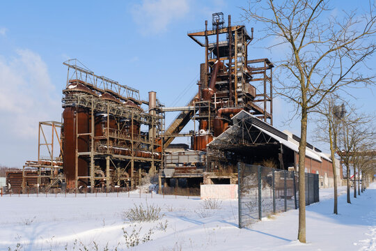 Abandoned blast furnace against sky during winter