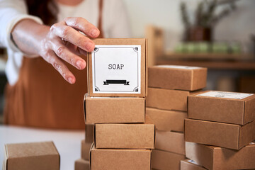 Woman stacking soap boxes at workshop