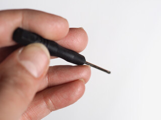 hand holding small screwdriver tool