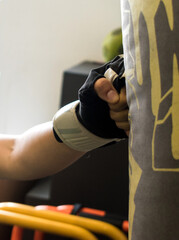 Detail of a fist of a woman hitting a punching bag 