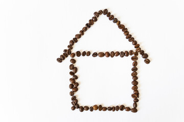 coffee beans on a white background in the shape of a house. homemade coffee.