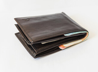 black wallet full of money on a white background. economy concept