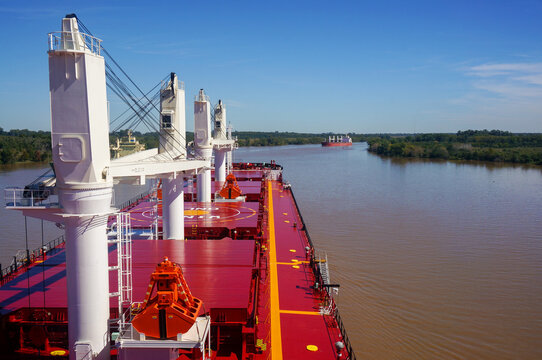 Vessel proceeding up the Parana River. Type of ship: Bulk carrier with cranes. Another ship is steaming in the opposite direction. Rio Parana.