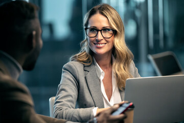Businesswoman smiling while looking at colleague in meeting at office