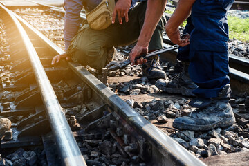 Obraz premium The worker tightened the screws on the rail with a large wrench in hand.