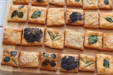 Domowe krakersy ozdobione listkami ziół, sezamem, makiem i solą © Monika