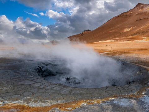 Steam emitting from geyser against mountain, Hverir, Iceland