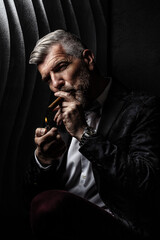 Portrait of a gentleman lighting a cigar