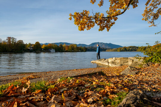 Man standing on rock at lakeshore