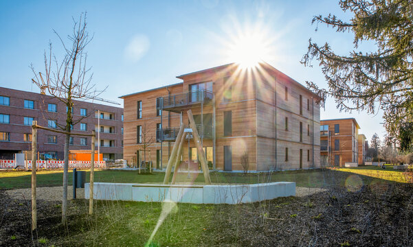 Germany, Bavaria, Munich, Sun shining over new development area with energy efficient wooden houses