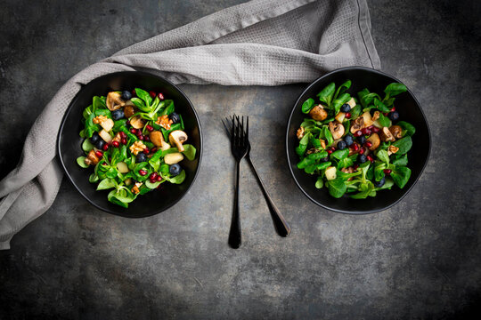 Autumn salad consisting of lambs lettuce, mushrooms, fried pears, blueberries, pomegranate seeds and walnuts
