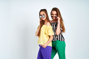 Two young women in stylish clothes fashion beauty studio shot on white background