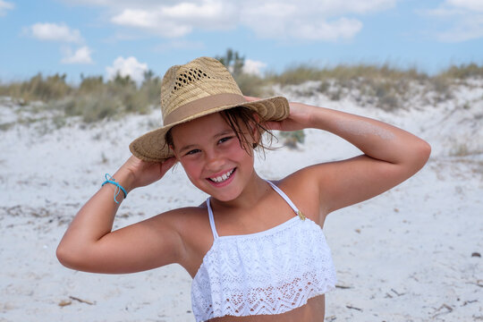Smiling girl wearing hat while standing at beach