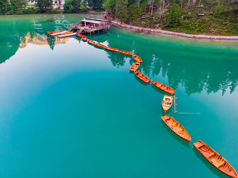 Rowboats moored on turquoise colored Pragser Wildsee lake at Dolomites, Alto Adige, Italy