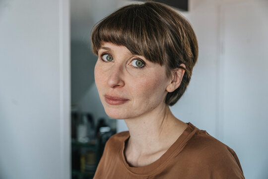 Mid adult woman with blank expression at home