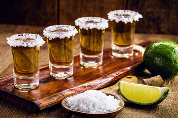 glasses of tequila on the bar table, served with salt and lemon