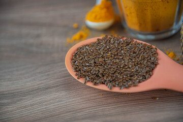 Flax seeds in silicone spoon on wooden background