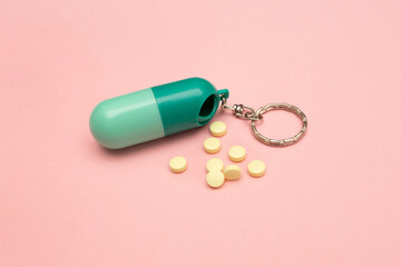 Travel pill box. Pill shape. The use of tablets in doses. Keep your health. Lots of yellow pills on a pink background.