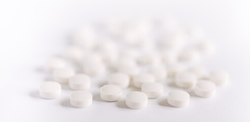 Fototapeta na wymiar White pills on a white background. round pills close-up. Healthcare and medicine.