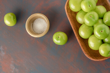 fresh ripe green plum fruits and salt on table