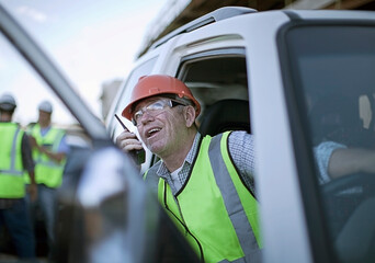 Portrait of construction worker sitting in car and talking on walkie-talkie