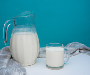A jug and a mug of fresh milk on the table on a blue background. Healthy and tasty breakfast in the village. selective focus. copy space for text. top view