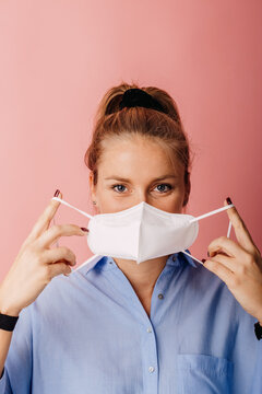 Mid Adult Businesswoman Wearing Protective Face Mask While Standing Against Colored Background