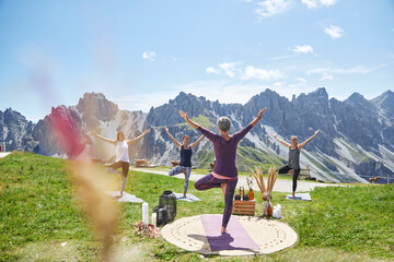 Active women doing hand raised exercise against mountain and sky