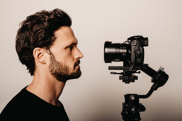 Bearded man looking at camera by beige background