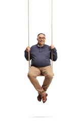 Mature man smiling and sitting on a wooden swing