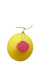 A yellow golden honeydew, with a red lantern tag hanging from its stalk. White background.
