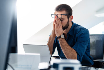 Businessman sitting with head in hands at office