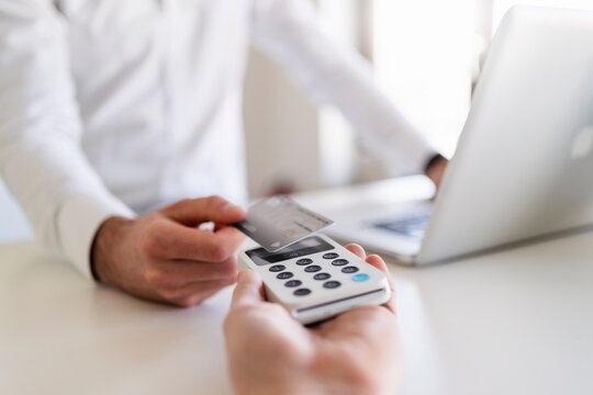 Businessman paying through debit card in office