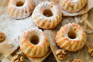 Traditional Wiener patisserie, mini bundt cakes, Gugelhupf (Gugelhopf) powdered with sugar, on the baking paper