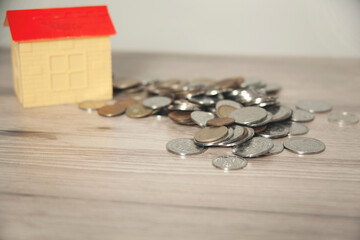 house model on with coins on desk